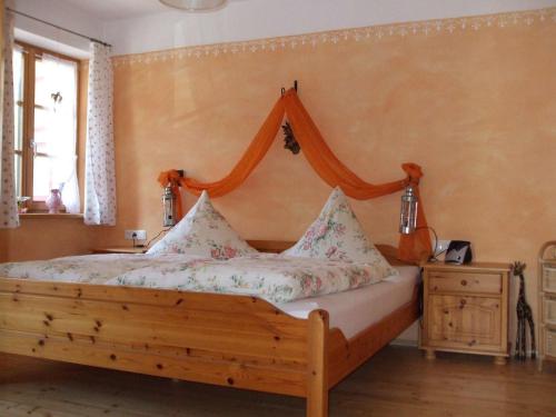 a bedroom with a wooden bed with a canopy at Weissenhof in Rottau