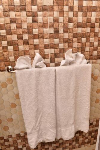 three towels are hanging on a towel rack in a bathroom at Chateau Margarita JA in Montego Bay