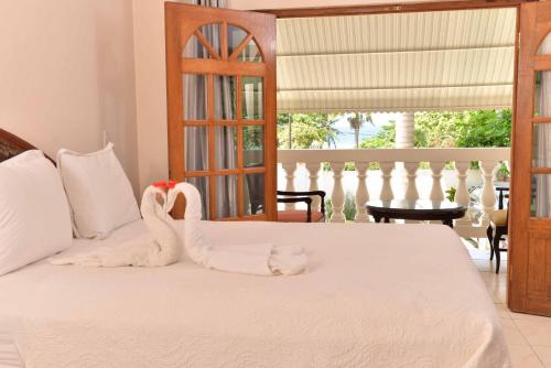 uma cama com um cisne feito de toalhas em Chateau Margarita JA em Montego Bay