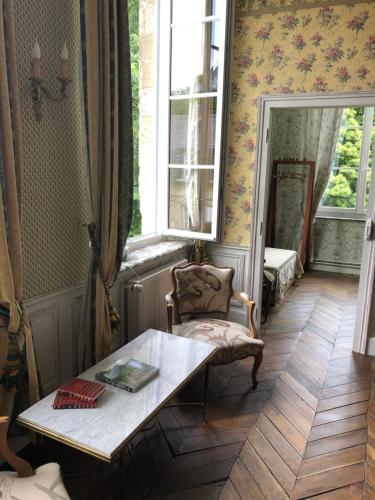 une chambre avec une table, une chaise et une fenêtre dans l'établissement Château d'en haut, à Jenlain