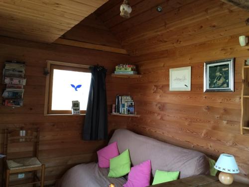 a living room with a couch in a log cabin at La Cabane aux Secrets - Au Milieu de Nulle Part in Outines