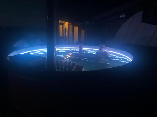a person sitting in a pool in a dark room at Ádám Apartman in Balatonföldvár