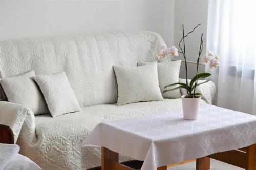 a living room with a white couch with a table at Apartmány LÍVIA Litmanová in Litmanová