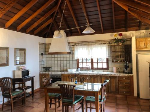 a kitchen with a table and chairs and a kitchen with a counter at Casa rural Los Llanos Negros in Fuencaliente de la Palma