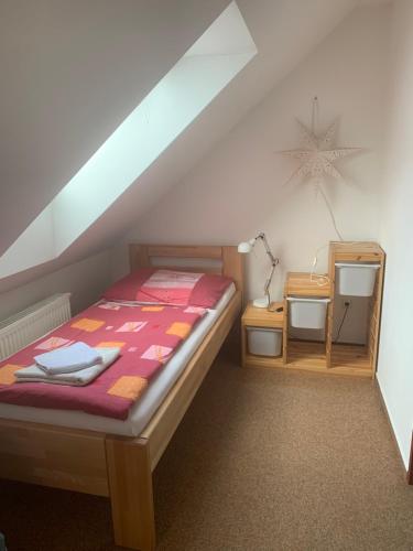a small bedroom with a bed and a table at Penzion Karlov in Karlov