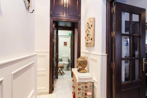 a hallway with a door and a statue on a box at Apartamento Alfarería in Seville