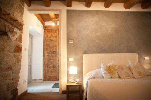 een slaapkamer met een bed en een tafel met een lamp bij Agriturismo Ostrouska in Sgonico