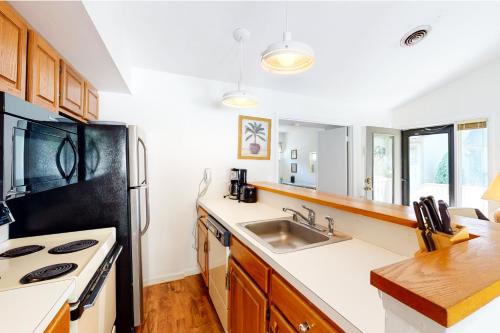 a kitchen with a sink and a black refrigerator at Sea Colony - 4003 Volley in Bethany Beach