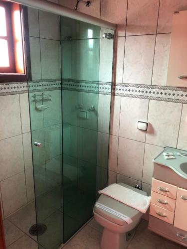 y baño con aseo y ducha acristalada. en Pousada Monte Suiço, en Campos do Jordão