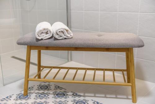 a stool in a bathroom with towels on it at TamTam Urban in Cluj-Napoca