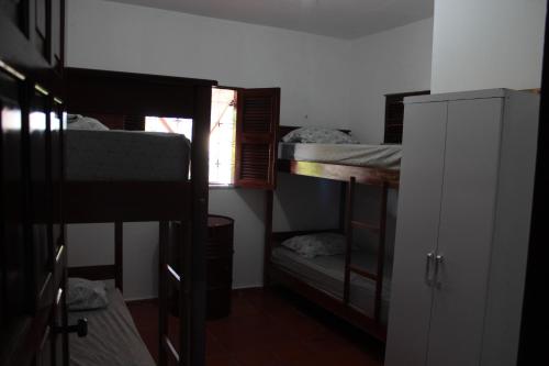 a room with three bunk beds and a window at Hostel 35 in Canoa Quebrada