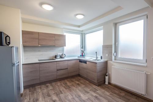 a kitchen with wooden cabinets and a large window at Chalet Keszthely in Keszthely