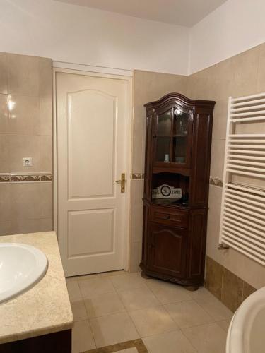 een badkamer met een wastafel en een houten kast bij Tori apartament in Târgu-Mureş