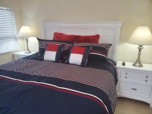 a bedroom with a large bed with red and white pillows at Ocean Side Resort - updated Villa in Hillsboro Beach