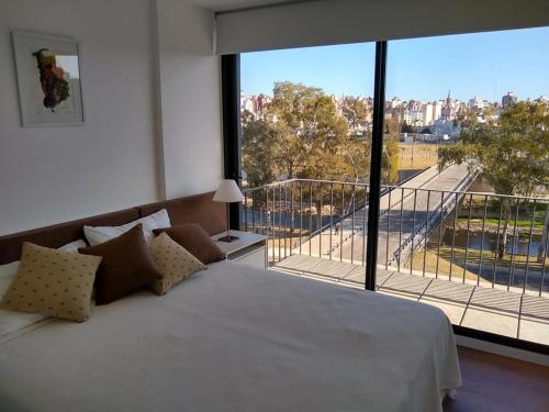 a bedroom with a large bed and a large window at Soul y Río in Córdoba