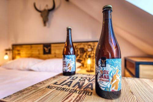 dos botellas de cerveza sentadas en una mesa en un dormitorio en Pivní Hotel, en Nepomuk