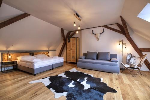 um quarto com uma cama e um sofá em Pivní Hotel em Nepomuk