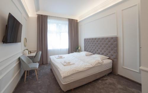 a bedroom with a large bed and a chair at Boleslav Home De Luxe in Sucha Beskidzka