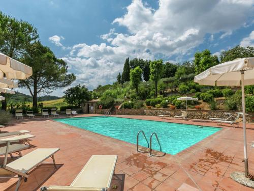 una piscina con sillas y sombrillas en un resort en Retreat in Siena s Countryside, en Siena