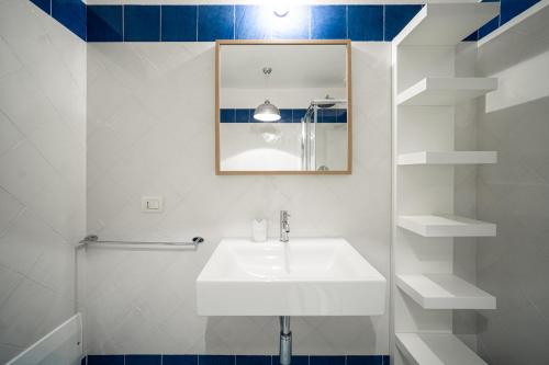 a white bathroom with a sink and a mirror at BGItalianVacation - Ville Li Conchi in Castiadas