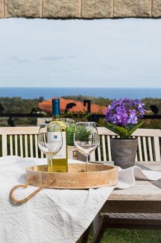 a bottle of wine and two wine glasses on a table at BGItalianVacation - Ville Li Conchi in Castiadas