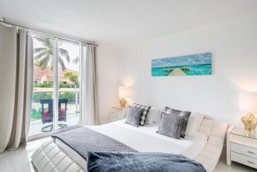a bedroom with a white bed and a large window at Luxury Miami Condos in Miami Beach