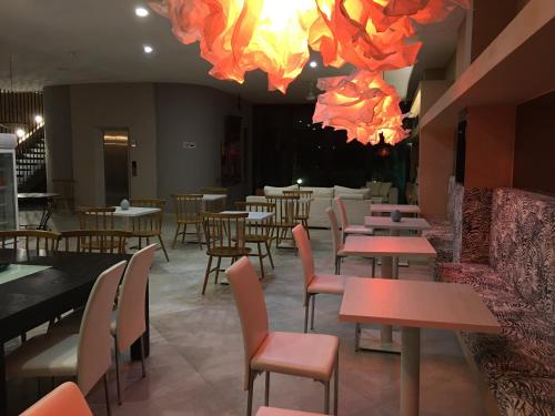 un ristorante con tavoli, sedie e luci di Arte Hotel a Santa Marta