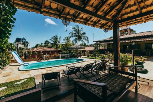 a patio with a pool and chairs and a swimming pool at Pousada Boa Vista in Barreirinhas
