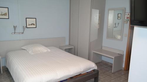 a small bedroom with a bed and a mirror at De Bonte Os Hotel & Tower in Roeselare