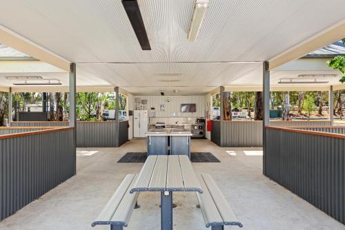 an empty building with a bench and a kitchen at Discovery Parks - Maidens Inn Moama in Moama