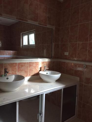 a bathroom with two sinks and a mirror at Apartamentos y Villas Michaela in Sosúa