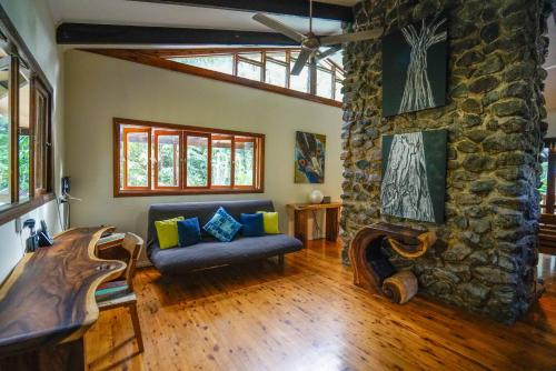 a living room with a couch and a stone wall at Wildwood in Cape Tribulation