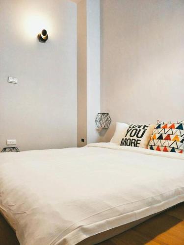 a bedroom with a large white bed with pillows at 湘品旅店Xiang Pin Hotel-東大門夜市-無電梯無電視 -花蓮縣旅館065號 in Hualien City