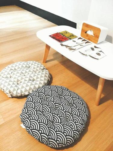 a table and a chair with a black and white ottoman at 湘品旅店Xiang Pin Hotel-東大門夜市-無電梯無電視 -花蓮縣旅館065號 in Hualien City