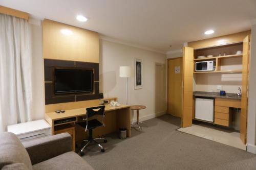 Cette chambre comprend un bureau avec un ordinateur et une télévision. dans l'établissement (103)Flat Executive Jardins (Apt. particular), à São Paulo