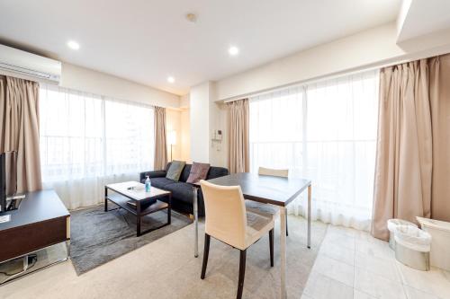 a living room with a table and a couch at Pangoo Shinagawa in Tokyo