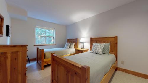 een slaapkamer met 2 bedden en een raam bij Lush Forest and Golf Course Views by Harmony Whistler in Whistler