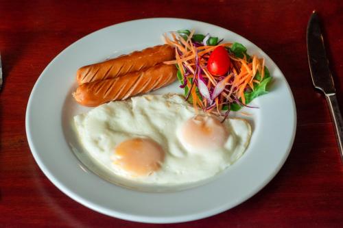 a plate of food with eggs and vegetables on a table at Sokdee City Hotel in Vientiane