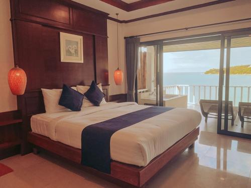 a bedroom with a bed with a view of the ocean at High Life Bungalow in Haad Yao