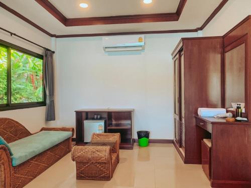 a living room with a couch and a chair at High Life Bungalow in Haad Yao