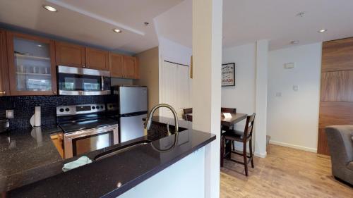 a kitchen with a stove top oven next to a table at Amazing Location with PRIVATE Hot Tub by Harmony Whistler in Whistler