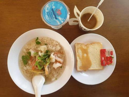 un piatto di cibo con una ciotola di zuppa e pane tostato di T'Luck House Resort a Haad Chao Samran