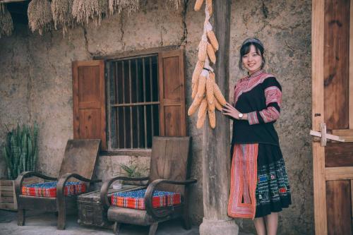 a woman standing in front of a house at homestay bongbang in Ha Giang