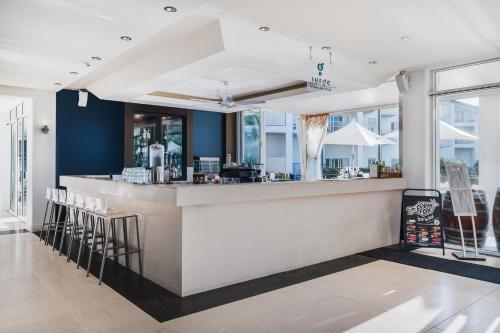 a restaurant with a bar with stools at Mantra on Salt Beach in Kingscliff