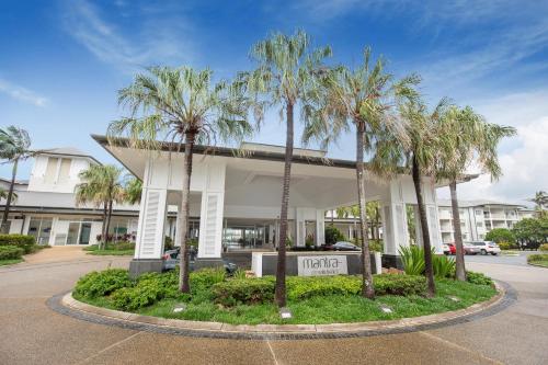 a hotel with palm trees in front of a building at Mantra on Salt Beach in Kingscliff