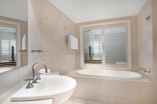金斯克里福的住宿－曼特拉鹽灘酒店，白色的浴室设有浴缸和水槽。