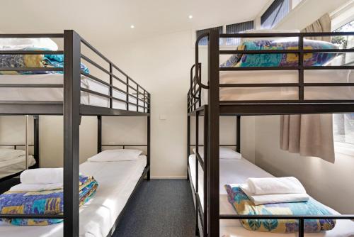 two bunk beds in a room with a window at Discovery Parks - Pambula Beach in Pambula