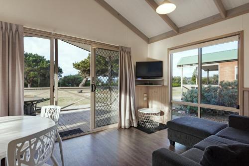 ein Wohnzimmer mit einem Sofa und einem Tisch in der Unterkunft Discovery Parks - Pambula Beach in Pambula