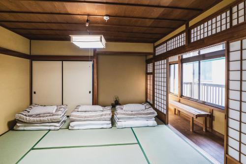松江市にあるKIAN the guest houseの窓のある部屋のベッド4台を利用する部屋