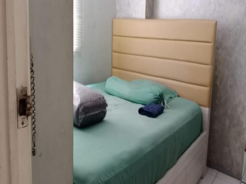 a bedroom with a bed with a head board at Sewaunitkalcit in Jakarta